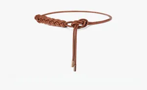 Detail of woven camel leather waist belt with elegant fringe and golden metal tips