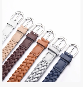 Detail of woven faux leather belts in various colors with polished silver buckles