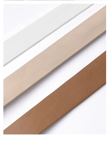 Close-up of pebble-textured PU leather belts in white, beige, and brown colors