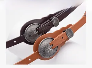 Close-up of vintage embossed leather belts with ornate round metallic buckles