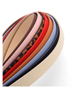 Detailed macro view showing multiple colorful faux leather belts with leopard print and textures