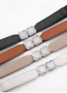 Variety of elastic waist belts in black, brown, khaki, and white with pearl buckle detail