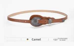 Detail of camel leather belt featuring vintage alloy buckle with ornate dragon carvings