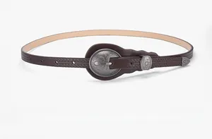 Detailed view of coffee leather belt with vintage floral buckle and braided texture