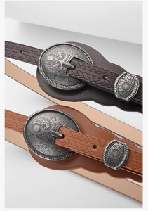 Detailed macro of vintage women's belts with ornate heart embossing and floral buckle