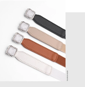 Detail of four retro elastic belts in black, beige, tan, and cream with marble buckles