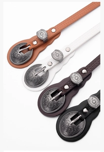 Detailed close-up of engraved alloy buckles on woven retro belts in four classic colors