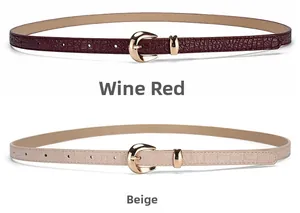 Détail de ceintures fines bordeaux et beige avec texture crocodile et boucle dorée