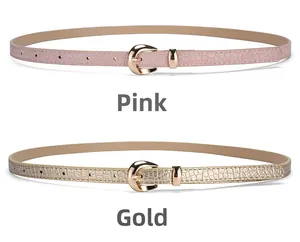 Détail de fines ceintures rose et or à effet crocodile avec boucles dorées polies