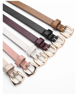 Close-up of slim colorful PU leather belts with gold buckles in various fashion shades