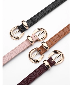 Détail de ceintures fines en cuir motif crocodile pour femmes avec boucle ovale dorée