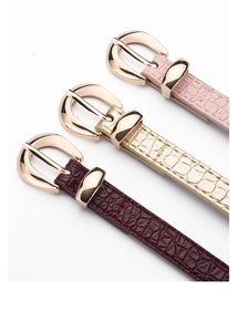 Détail de trois ceintures fines motif crocodile en rose, champagne et bordeaux avec boucles d'or