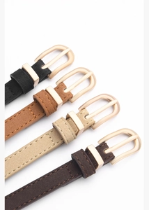 Dettaglio di cinture sottili in pelle PU in nero e marrone con fibbia ad ardiglione oro