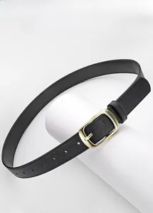 Gros plan sur une ceinture en cuir noir texturé avec boucle carrée en métal doré poli