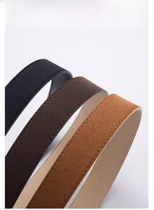 Gros plan de ceintures en similicuir noir, marron foncé et camel avec coutures fines
