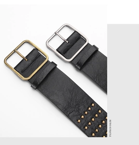Detail of two retro black leather belts with bronze rivets and silver square buckles