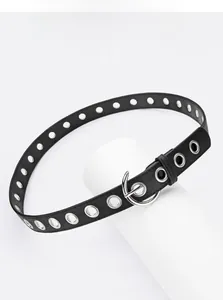 Detail of black punk style belt with silver metal eyelets and a round buckle closure