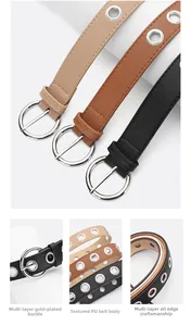 Detail of trendy punk grommet belts featuring round metal eyelets and silver buckles