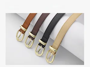 Détail de quatre ceintures fines en similicuir avec boucles dorées ovales sur fond blanc