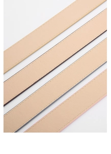 Gros plan de ceintures en cuir beige minimalistes avec couture de précision et texture