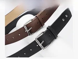 Close-up of black and brown leather belts with polished silver needle buckles on white props