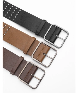 Detail of punk style wide belts with double rows of metal eyelets and vintage silver buckles