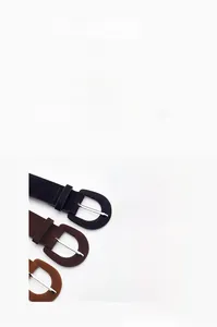 Détail de trois ceintures en suédine noire et marron avec boucles en métal argenté