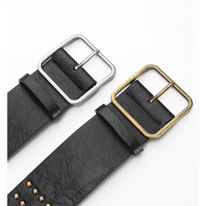 Macro shot of punk style black leather belts with metal square buckles and studs