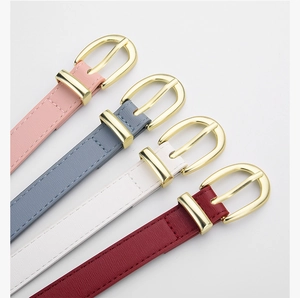 Détail de fines ceintures en cuir de quatre couleurs avec boucles dorées ovales