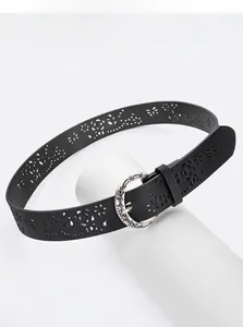 Macro detail of black belt with laser-cut floral patterns and vintage carved metal buckle