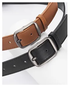 Detail of matte silver alloy buckle on black and brown leather belts for jeans