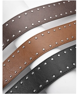 Détail de trois ceintures en cuir à clous en marron et noir avec rivets vintage