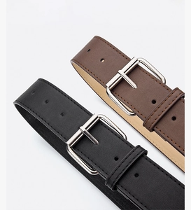 Detailed view of black and dark brown PU leather belts with silver polished metal buckles