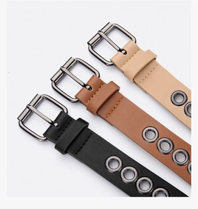Detail of slim leather belts with metal eyelets and pin buckle in black, brown and beige