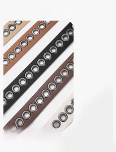 Detail of slim leather belts with metal eyelets in khaki, brown, and black colors
