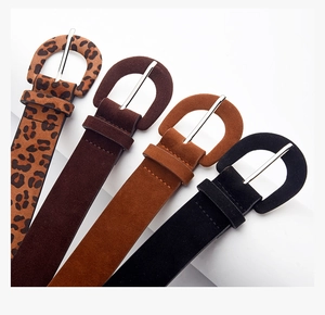 Détail de quatre ceintures en daim léopard, marron, camel et noir avec boucles rondes