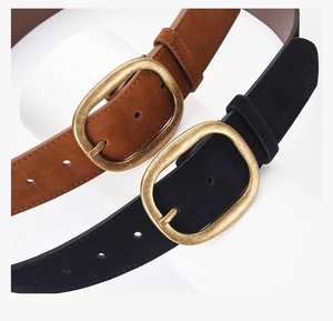 Close-up of premium faux suede belts in brown and black with vintage oval metal buckles