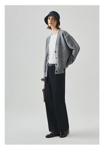 Ganzkörperansicht der grauen Strickjacke mit weit geschnittener Jeans und Lederhandtasche