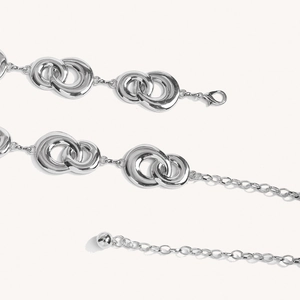 Detail of silver metal waist chain showing interlocking double rings and lobster clasp