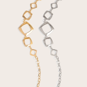 Detailaufnahme hohler geometrischer Metall-Taillenkette in Gold- und Silbertönen