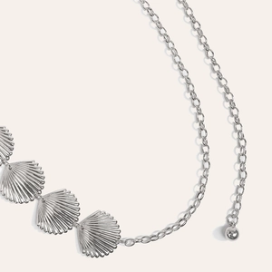 Vue détaillée de la chaîne en métal argenté avec pendentifs coquillages et perle ronde