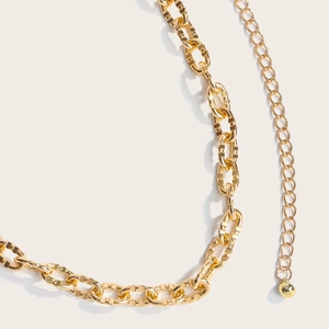 Detailed close-up of hollow gold metal waist chain with adjustable links and ball pendant