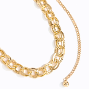 Detailed macro view of the polished golden alloy chain links and sleek round ball pendant