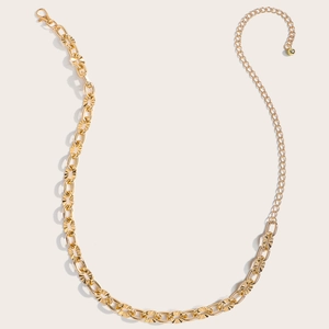 Detailed close-up of textured gold chain belt with adjustable lobster clasp and sphere charm