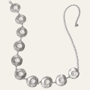 Detailed close-up of silver metal chain belt with pearl-inlaid sunburst discs and adjustable end
