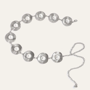 Detailed macro view of silver metal disc waist chain featuring pearls and radial textures