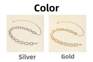 Dettaglio di catene in vita rettangolari con maglie testurizzate in finiture oro e argento
