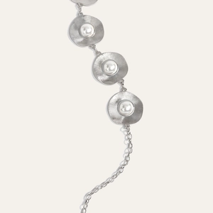 Detail of silver metal chain belt with sunburst round charms and inlaid pearls