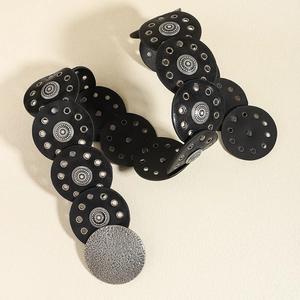 Detalle de cinturón de cuero negro vintage con ojales plateados y motivos de estrellas
