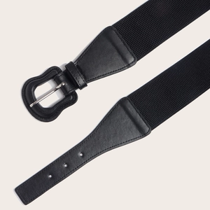 Detail of black elastic waist belt with matte wavy buckle and textured faux leather